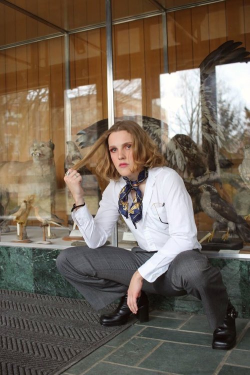 A portrait of a model in front of UVM's taxidermy collection